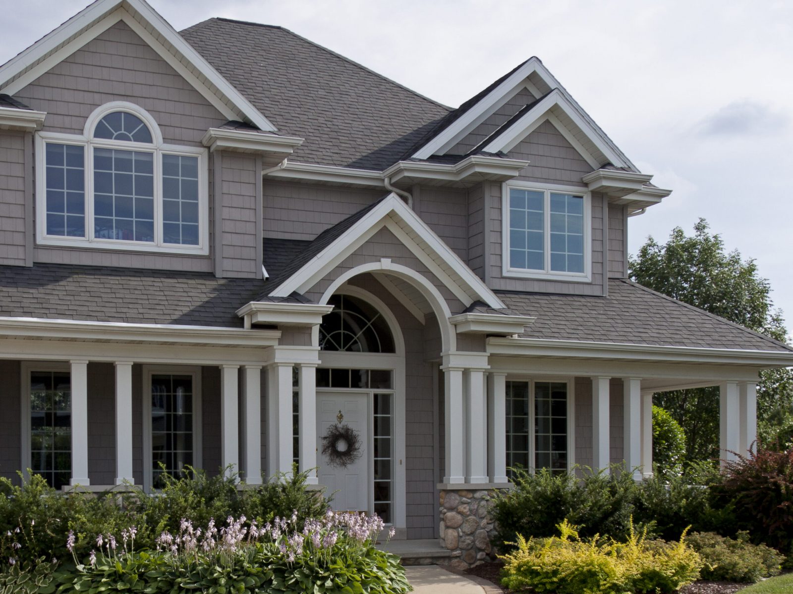The front of a beautiful luxury home in a typical suburban neighborhood.